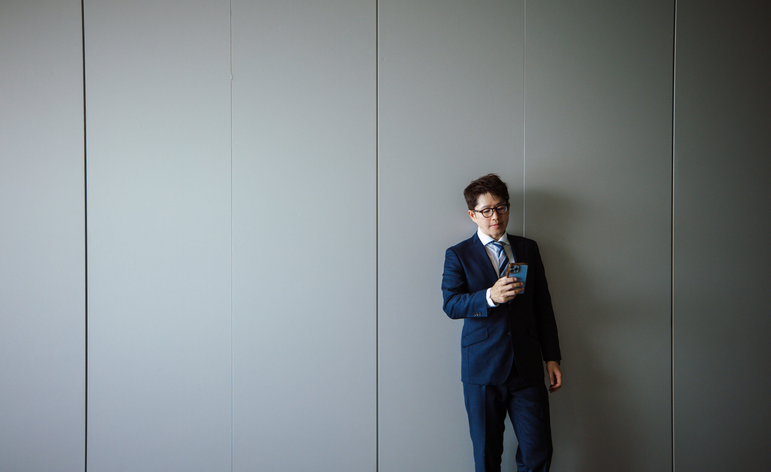 壁際に立つ男性