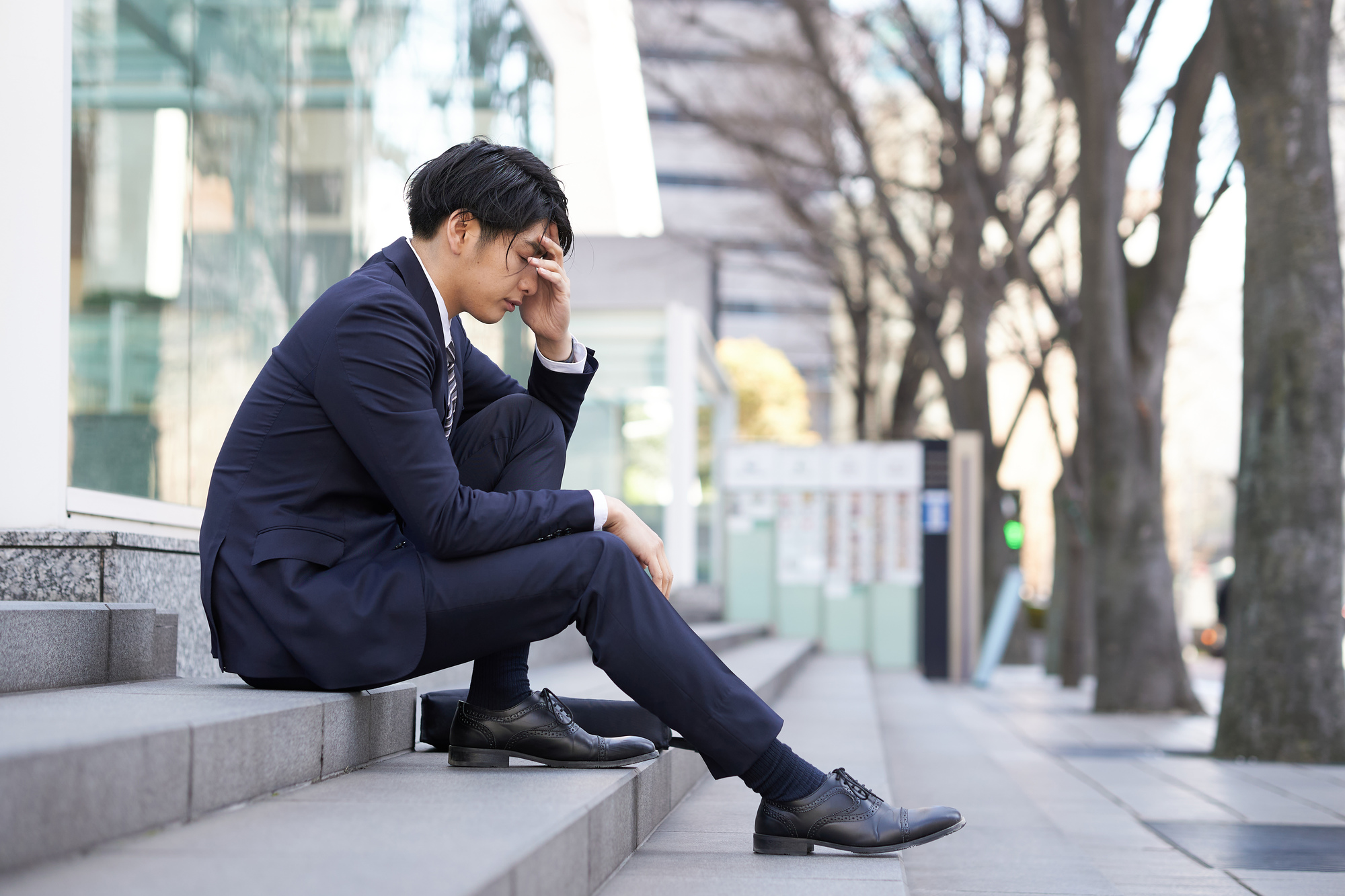 座って悩んでる男性