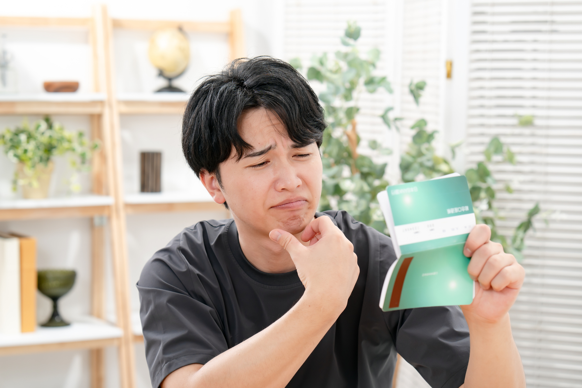 通帳を見て生活が不安な様子の男性