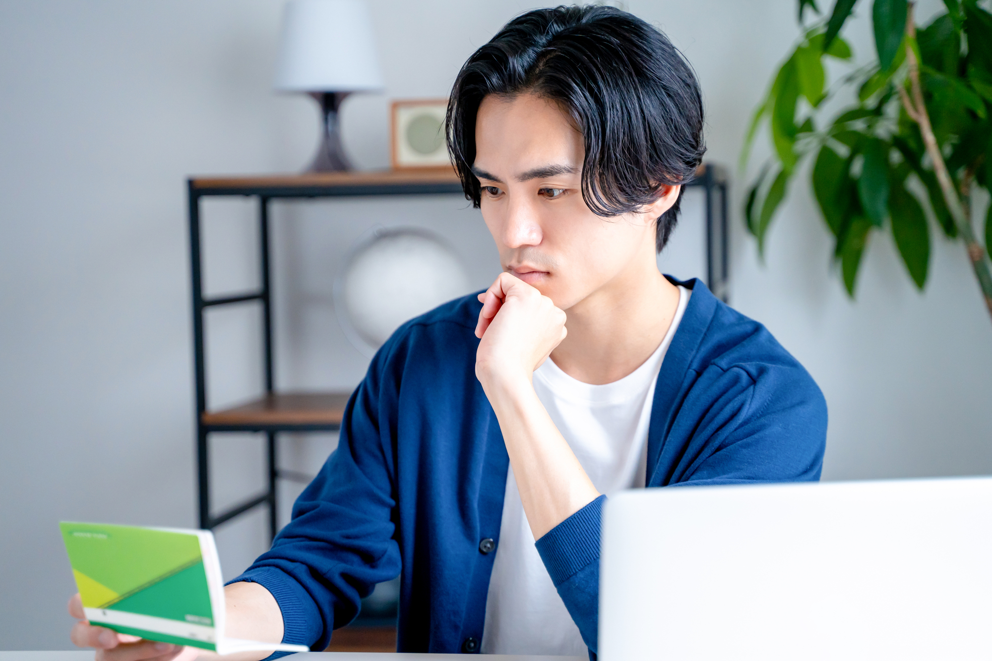 通帳を見て何か考えている様子の男性