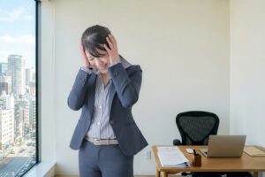 オフィスで頭を抱える女性会社員